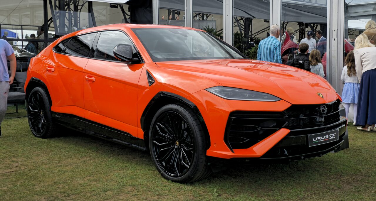 Lamborghini Urus SE laranja estacionado na grama de um evento ao ar livre